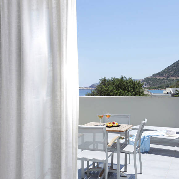 Terrace with dining table, sun loungers and a view of sea and hills