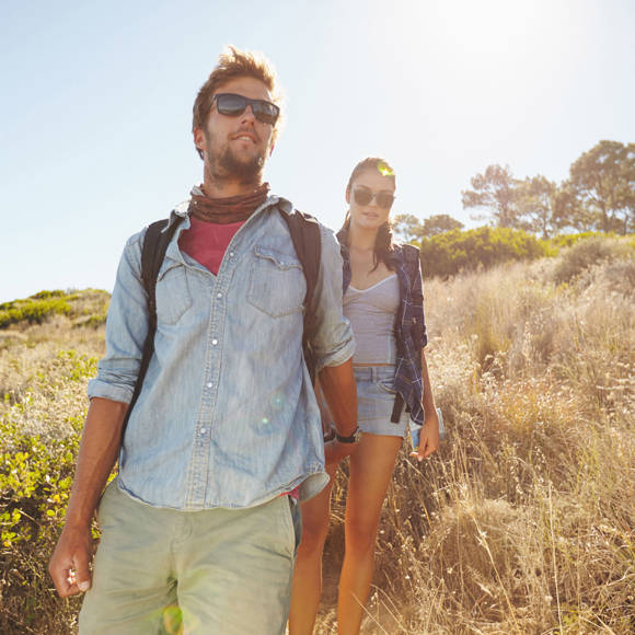 Couple hiking on a sunny day in Crete, enjoying the scenic views and natural surroundings
