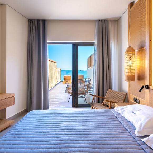 Junior suites with a double bed, pendant lighting and direct access to a private terrace with a pool and sea view